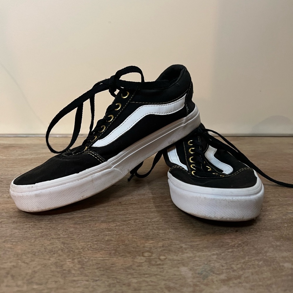 Black low top lace up Vans with gold hardware
